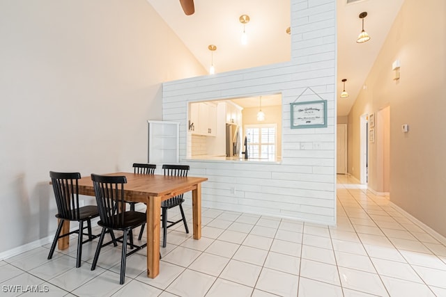 dining area with high vaulted ceiling and light tile patterned floors