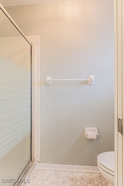 bathroom featuring toilet and an enclosed shower