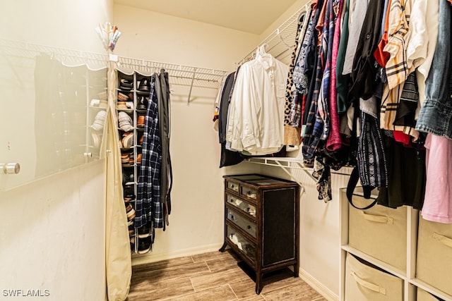 walk in closet with light hardwood / wood-style flooring