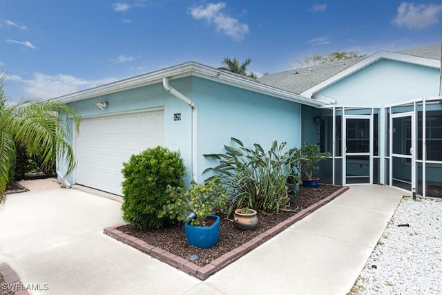 ranch-style house featuring an attached garage, driveway, and stucco siding