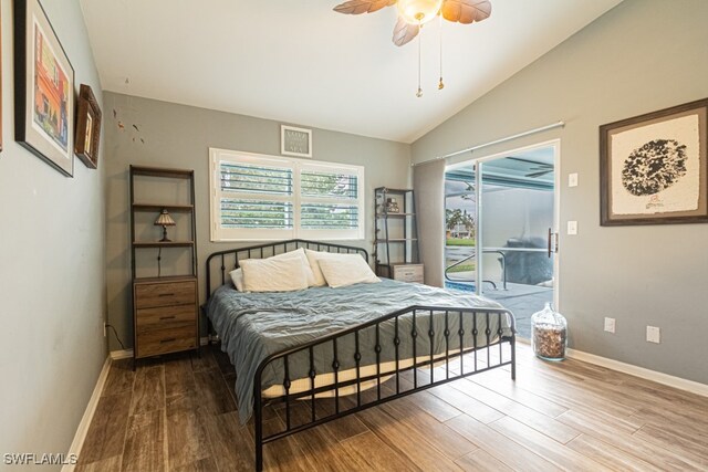 bedroom with hardwood / wood-style floors, vaulted ceiling, access to exterior, and ceiling fan