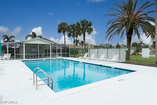 view of swimming pool featuring a patio and glass enclosure