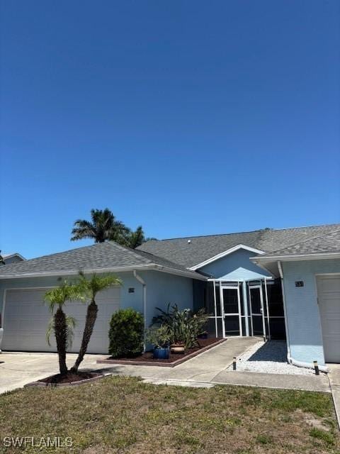 back of property with an attached garage and driveway