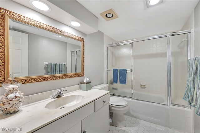 full bathroom featuring shower / bath combination with glass door, vanity, tile patterned flooring, and toilet