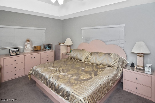 bedroom with dark colored carpet and ceiling fan