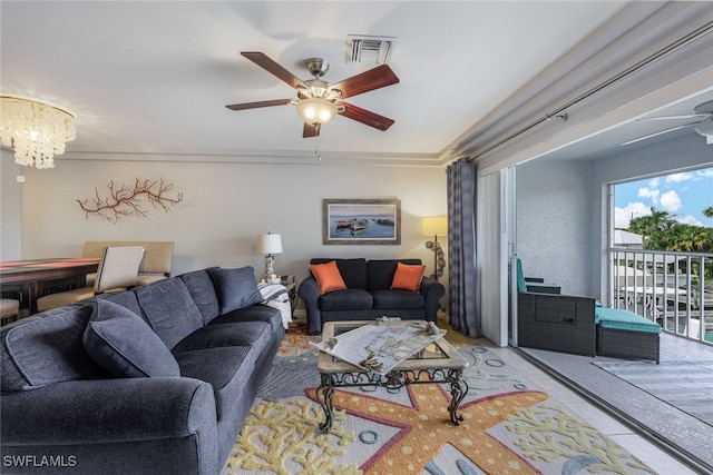 living room featuring ceiling fan with notable chandelier and crown molding