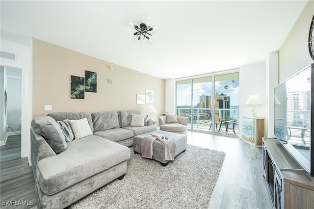 living room with hardwood / wood-style flooring and a wall of windows