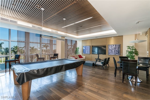 game room featuring billiards, a tray ceiling, floor to ceiling windows, and dark hardwood / wood-style flooring