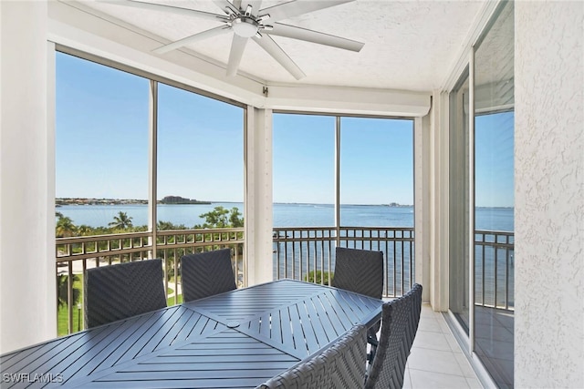 unfurnished sunroom with a water view and ceiling fan