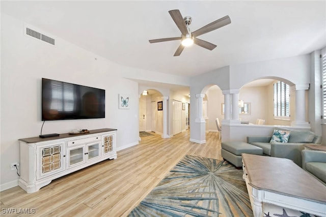 living room with light wood-type flooring, ceiling fan, and ornate columns