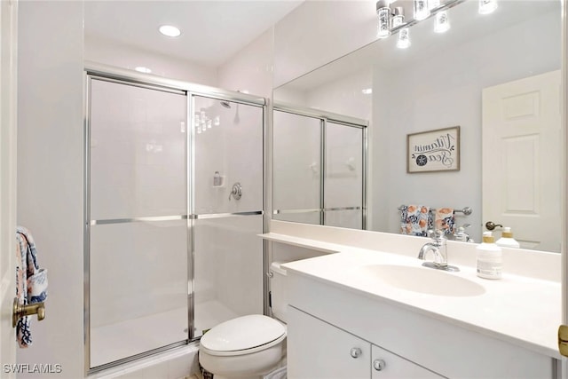 bathroom featuring vanity, toilet, and an enclosed shower