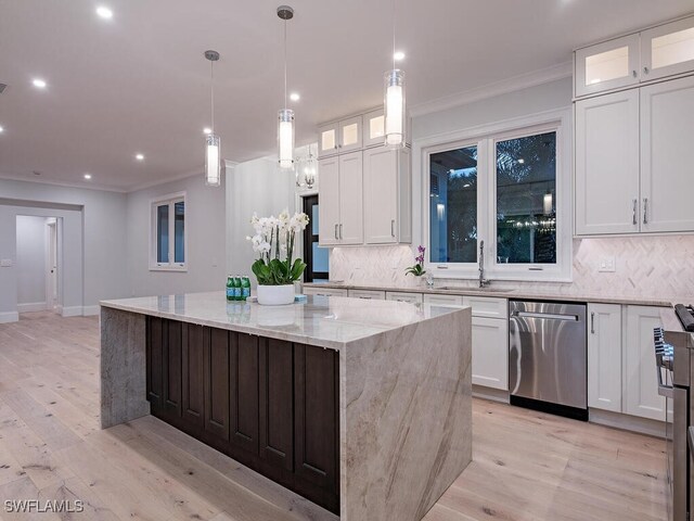 kitchen with white cabinetry, a center island, light stone counters, and stainless steel dishwasher