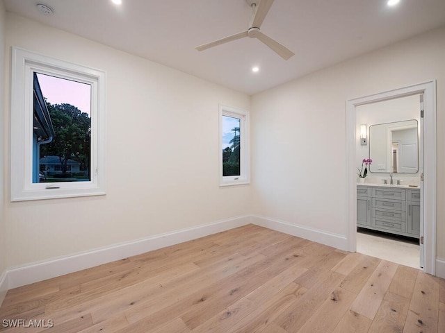 unfurnished bedroom with sink, connected bathroom, and light hardwood / wood-style floors