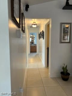 hallway with light tile patterned flooring and baseboards