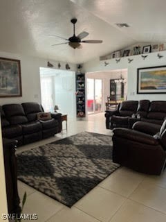 living room featuring vaulted ceiling, visible vents, ceiling fan, and light tile patterned floors