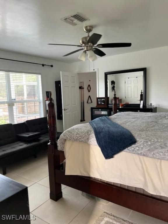 bedroom with light tile patterned floors, ceiling fan, and visible vents