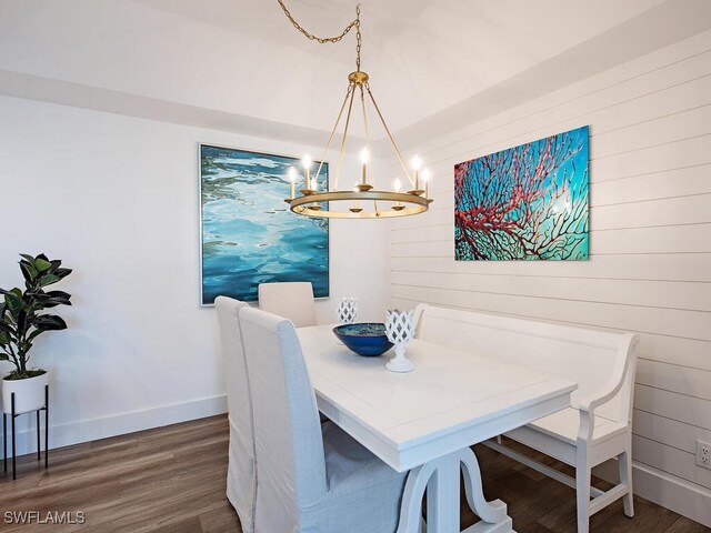 dining area with dark wood-type flooring and a chandelier