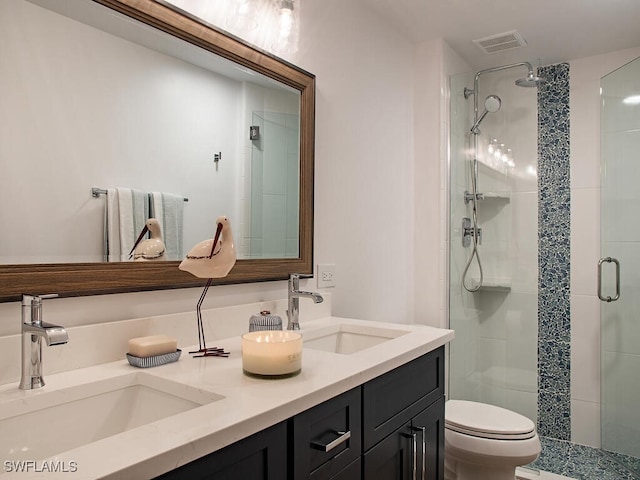 bathroom featuring a shower with shower door, vanity, and toilet