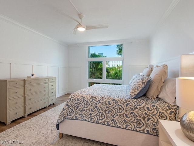 bedroom with crown molding, light hardwood / wood-style floors, and ceiling fan