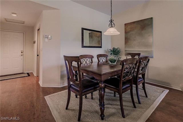 dining space featuring baseboards and dark wood-style flooring