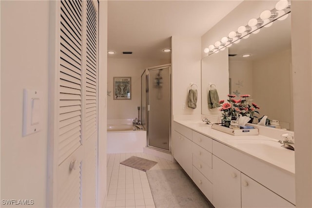 bathroom featuring a bath, a shower stall, tile patterned floors, and a sink