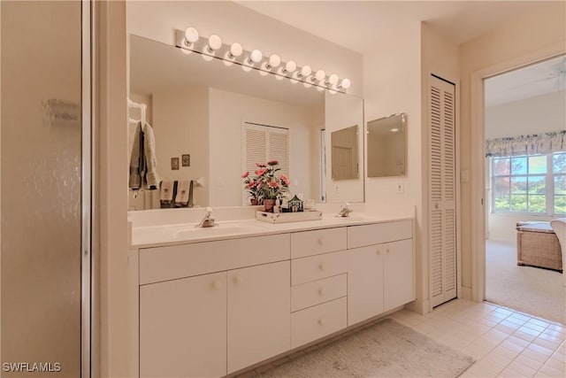 bathroom with double vanity, a closet, tile patterned floors, and a sink
