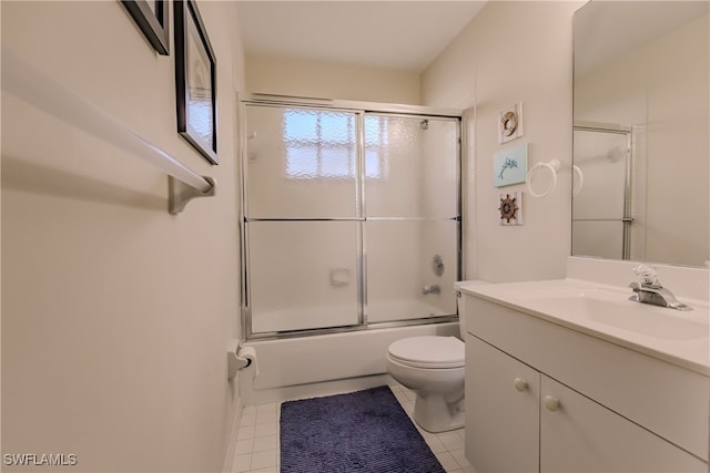 full bathroom featuring vanity, bath / shower combo with glass door, toilet, and tile patterned flooring