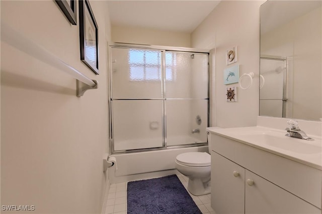 full bath with tile patterned flooring, bath / shower combo with glass door, toilet, and vanity