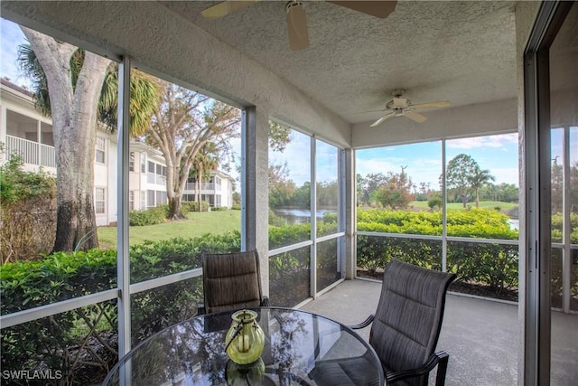 sunroom / solarium featuring plenty of natural light, a water view, outdoor dining area, and ceiling fan
