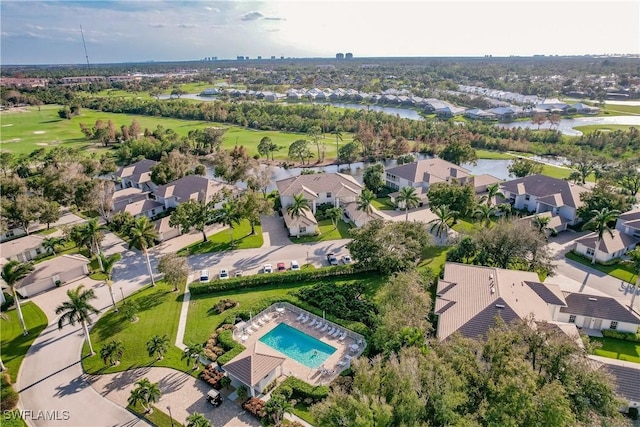 drone / aerial view featuring view of golf course, a water view, and a residential view