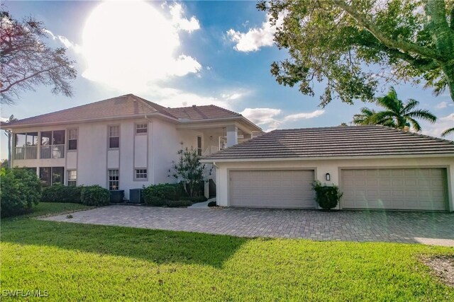 mediterranean / spanish-style house featuring cooling unit, a front lawn, and a garage