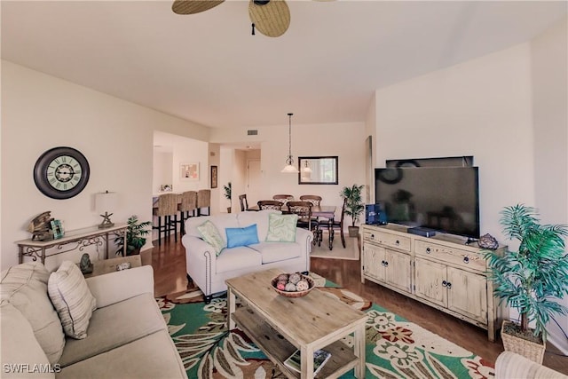 living room featuring visible vents, dark wood-style floors, and ceiling fan