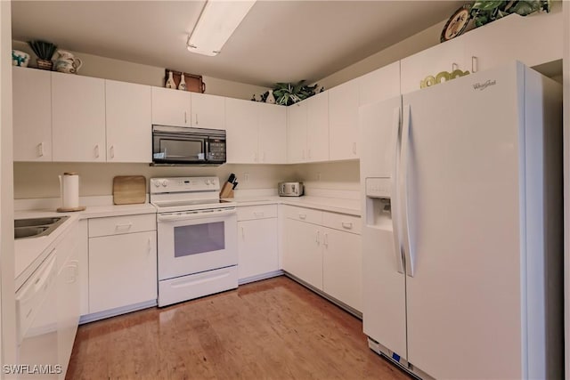 kitchen featuring white cabinets, light countertops, a sink, white appliances, and light wood-style floors