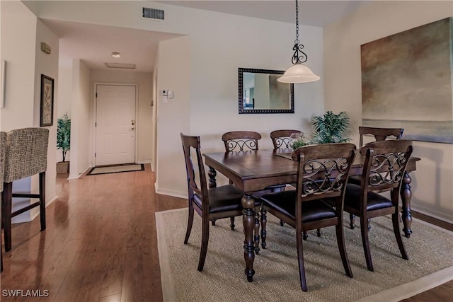 dining space featuring dark wood finished floors, baseboards, and visible vents