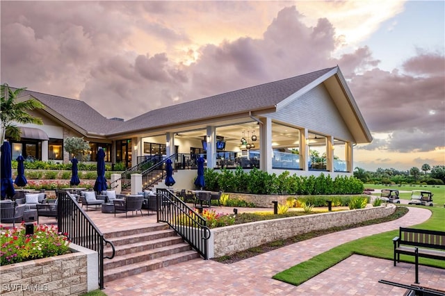 view of property's community featuring a patio area, an outdoor hangout area, and stairs