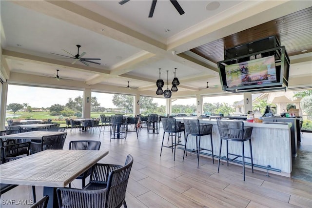 view of patio / terrace with outdoor wet bar, outdoor dining space, and a ceiling fan