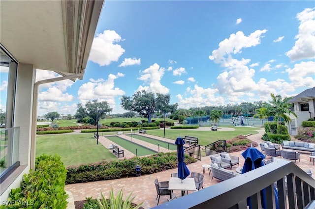 balcony with an outdoor living space and golf course view