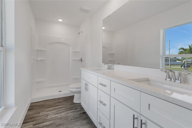 bathroom featuring walk in shower, vanity, toilet, and hardwood / wood-style flooring