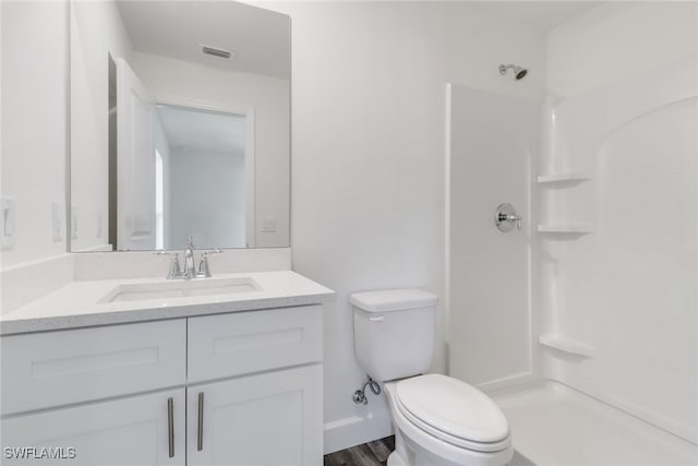 bathroom featuring vanity, walk in shower, toilet, and wood-type flooring