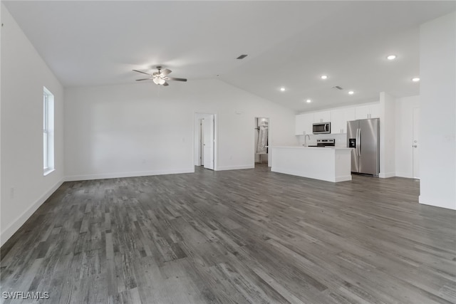 unfurnished living room with dark wood-type flooring, vaulted ceiling, sink, and ceiling fan