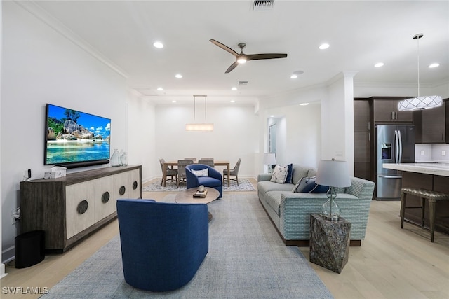 living room featuring ornamental molding, light wood-type flooring, and ceiling fan