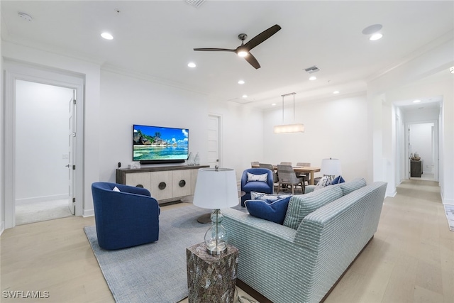 living room with ceiling fan, light wood-type flooring, and crown molding