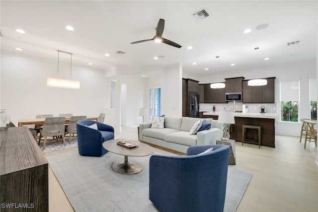 living room featuring ceiling fan and light hardwood / wood-style flooring