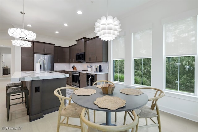 kitchen featuring stainless steel appliances, crown molding, sink, and a wealth of natural light