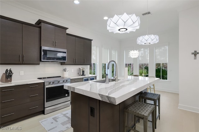 kitchen with tasteful backsplash, plenty of natural light, appliances with stainless steel finishes, and sink