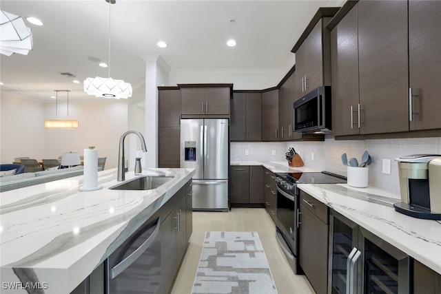 kitchen featuring pendant lighting, tasteful backsplash, dark brown cabinetry, sink, and appliances with stainless steel finishes