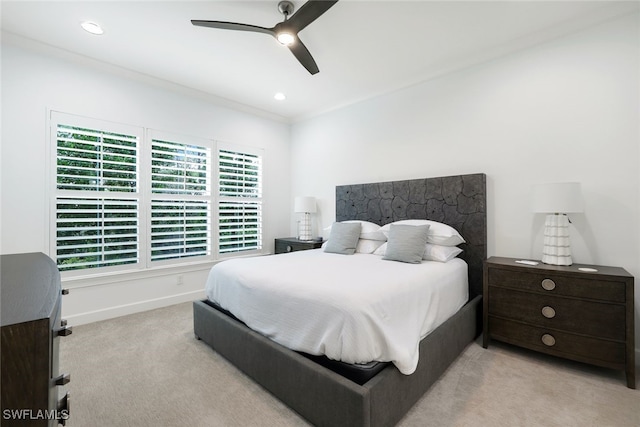 carpeted bedroom featuring ceiling fan and crown molding