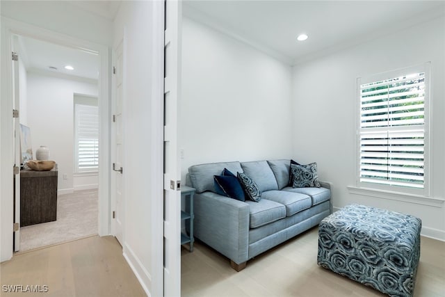 sitting room with ornamental molding and hardwood / wood-style floors