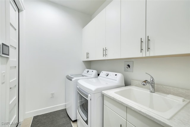 washroom with washing machine and dryer, sink, and cabinets