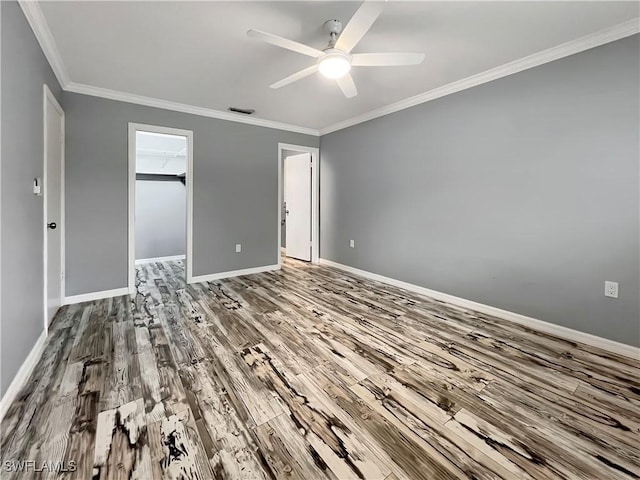 unfurnished bedroom featuring hardwood / wood-style flooring, ceiling fan, a spacious closet, and a closet